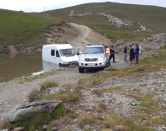 Microbuz plin cu turişti rămas blocat într-o zonă cu apă şi nămol, pe Transalpina