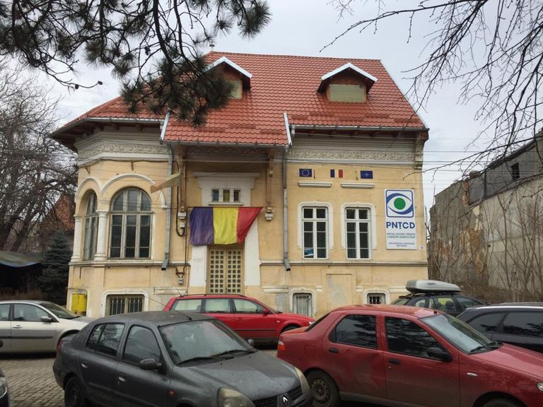 La PNȚCD s-a decolorat și steagul. Dar clădirea încă rezistă.