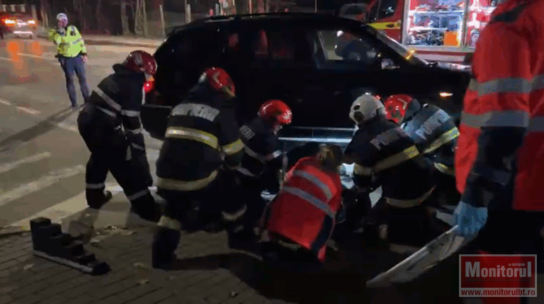 Pompierii scot de sub o mașină un pieton.